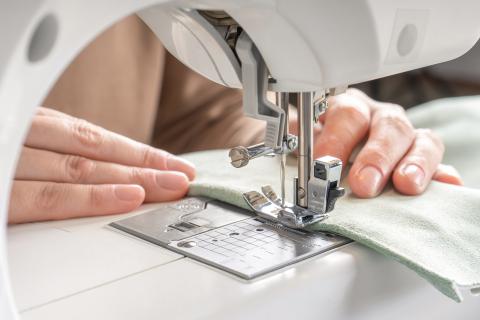 close up of hands using a sewing machine